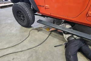 A car getting welding done in the undercarriage
