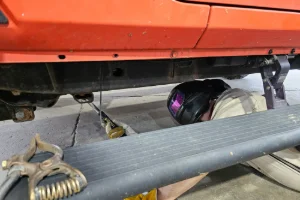 A car getting welding done in the undercarriage