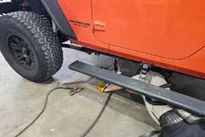 A car getting welding done in the undercarriage