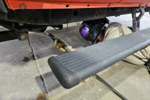 A car getting welding done in the undercarriage